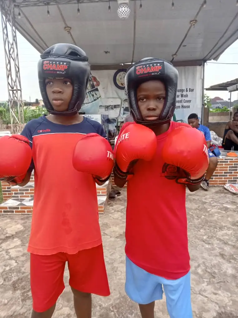 Two kids in headgear and red gloves, guards up