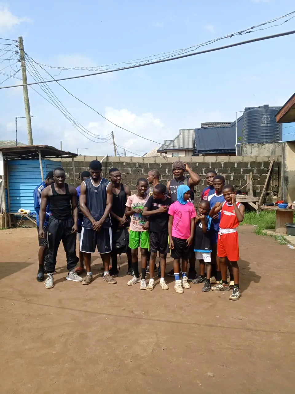 Coaches and young boxers of all ages lined up together on the training yard